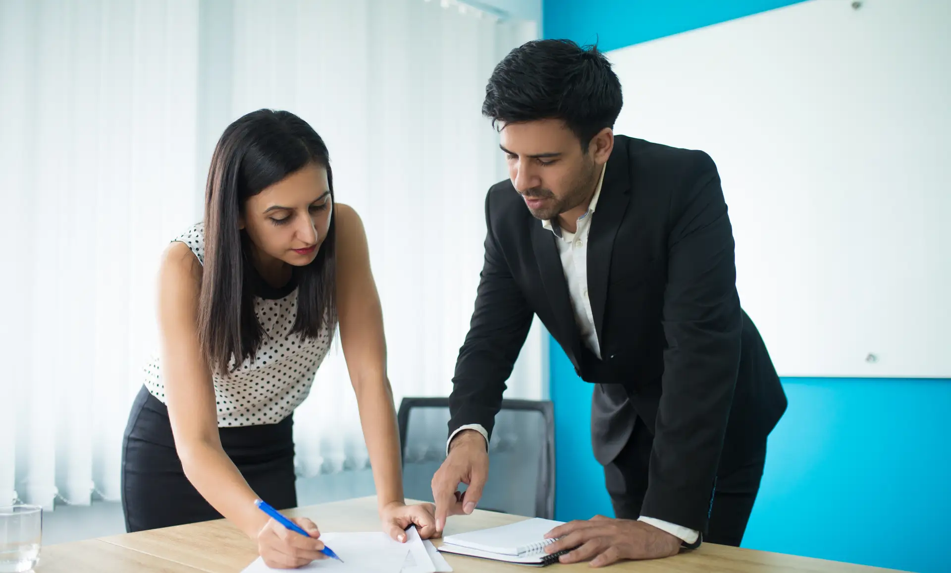 Serious businessman and businesswoman signing contract